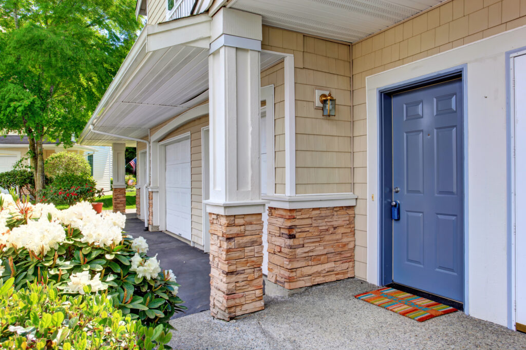 Column entrance porch with blue door and colorful rug