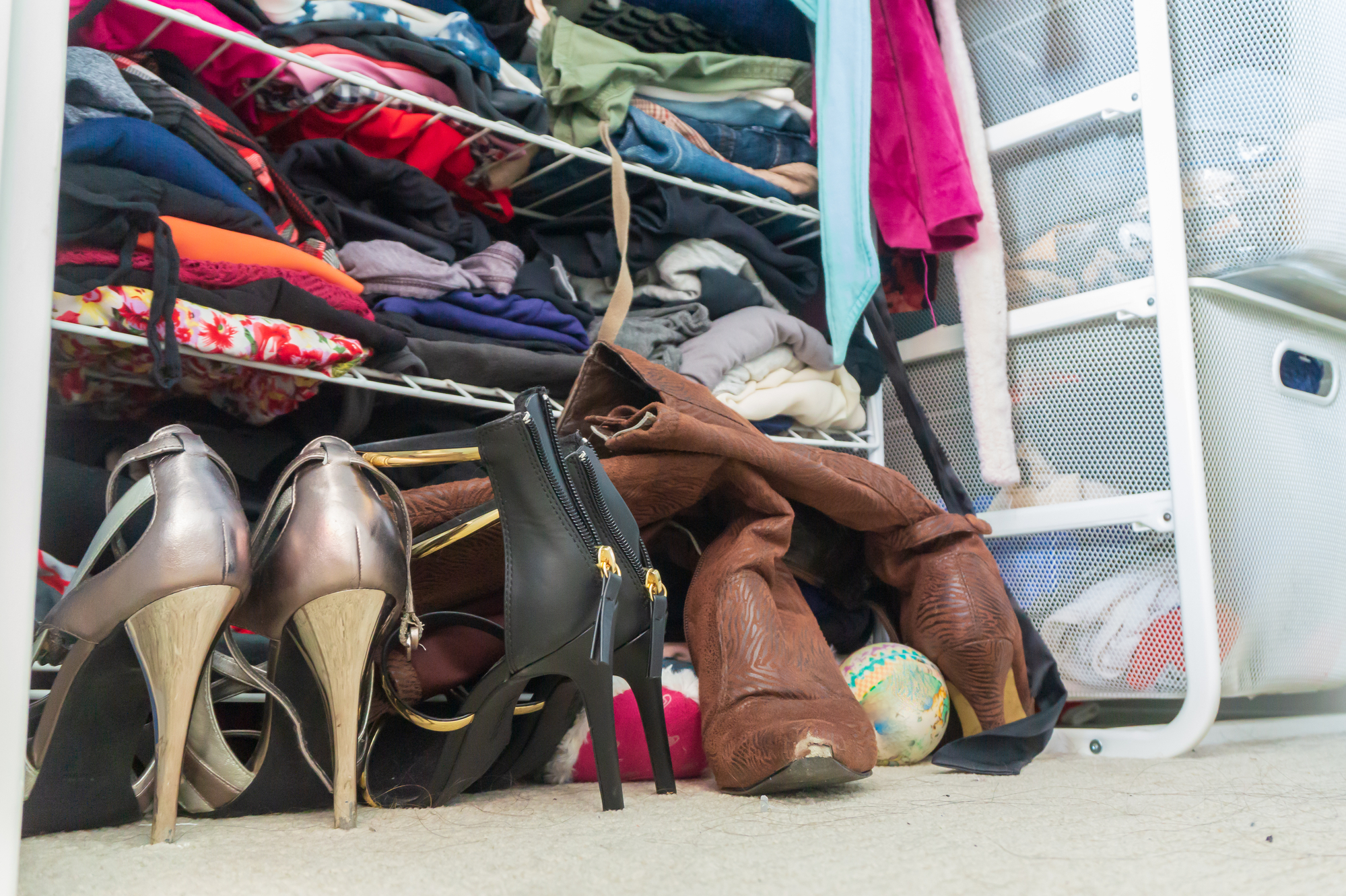 womens closet cluttered with high heel shoes