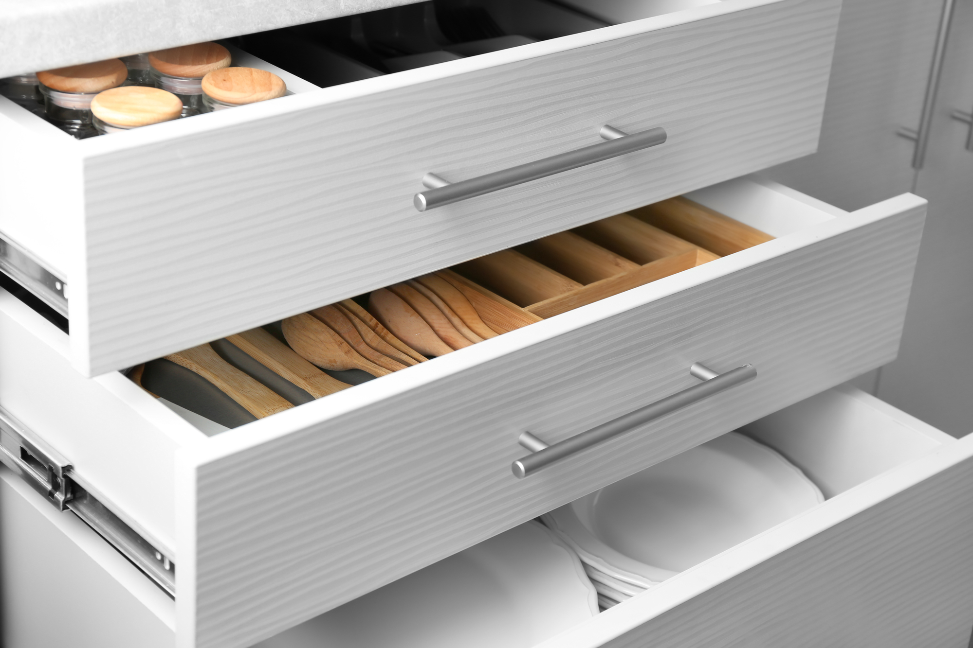 Set of ceramic plates and utensils in kitchen drawers