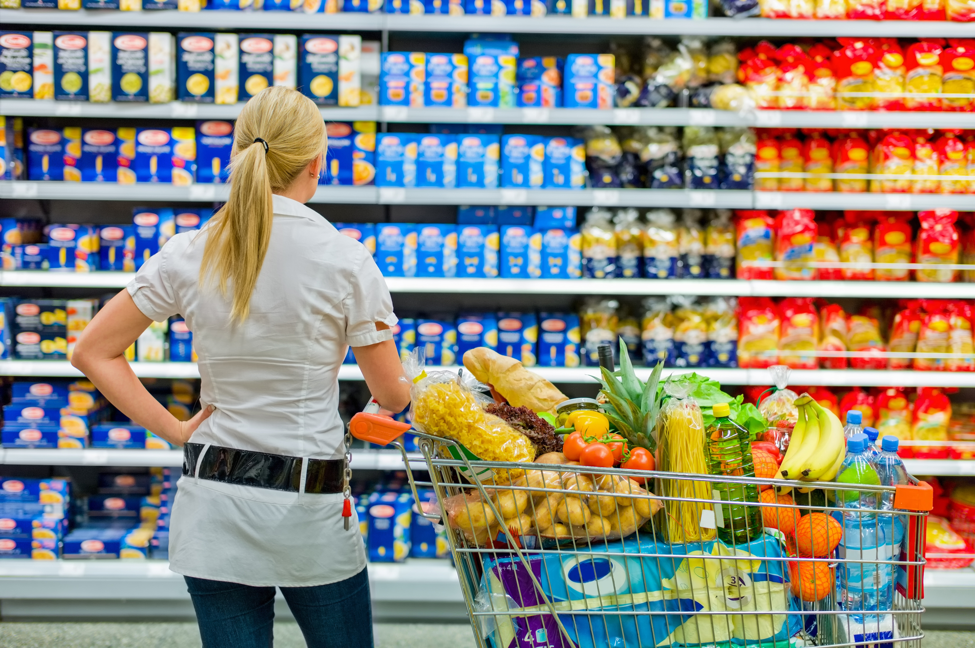 a woman is overwhelmed with the wide range in the supermarket when shopping.