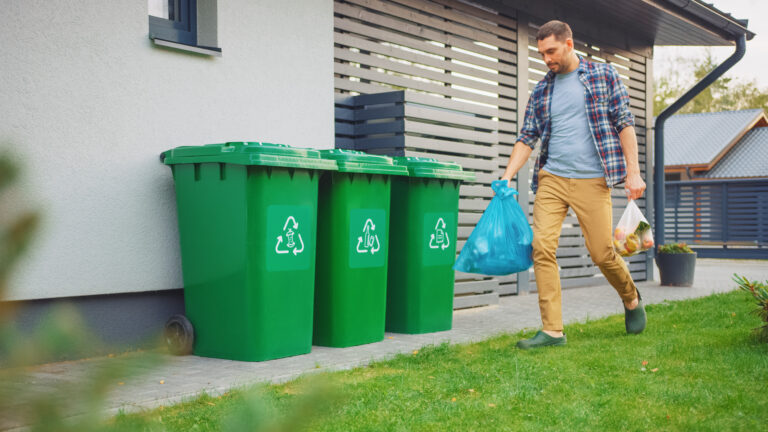 man walking taking food to trash can