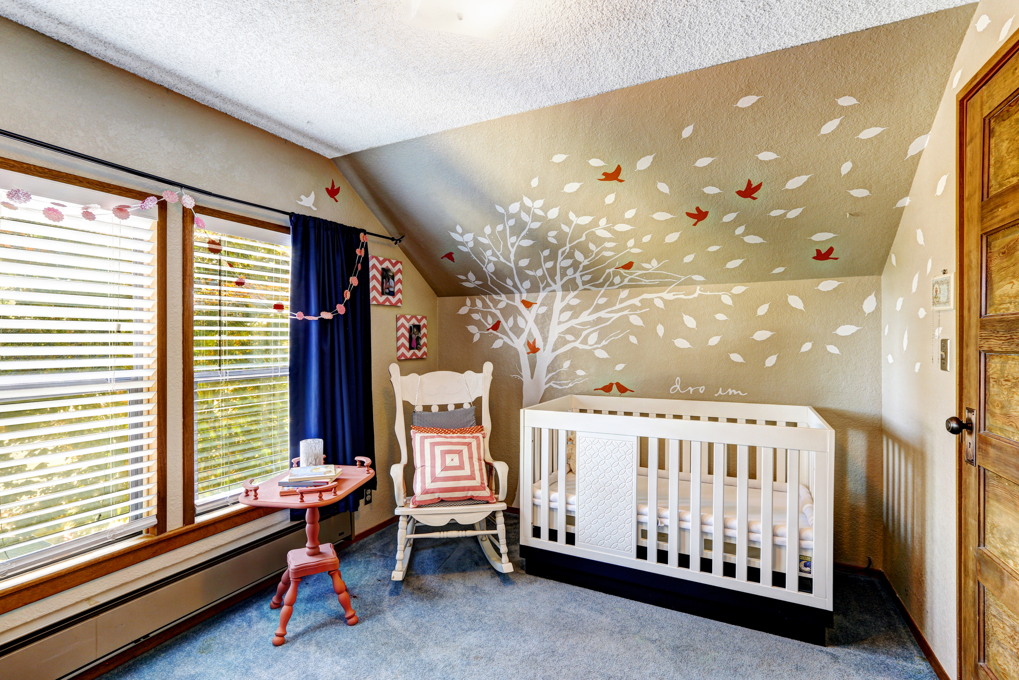 Cozy nursery room with murals, white crib and rocking chair