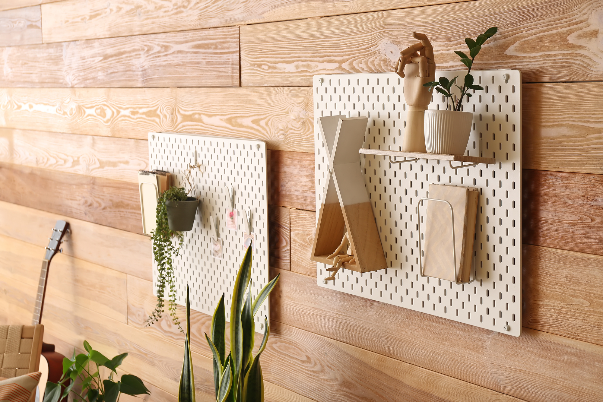 Pegboards with decor on wooden wall in room