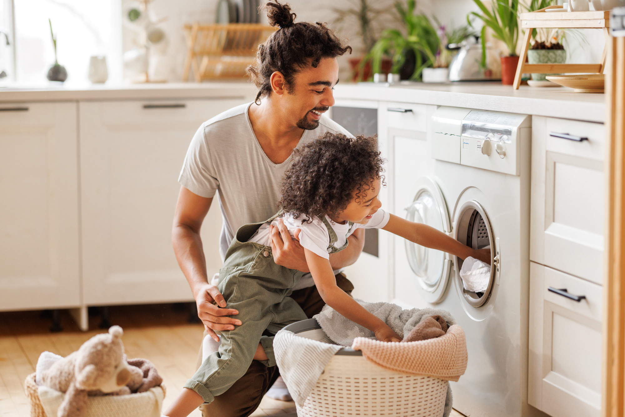 Son helping dad to load washing machine