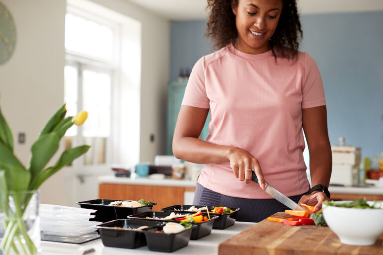 Woman Preparing Batch Of Healthy Meals At Home In Kitchen