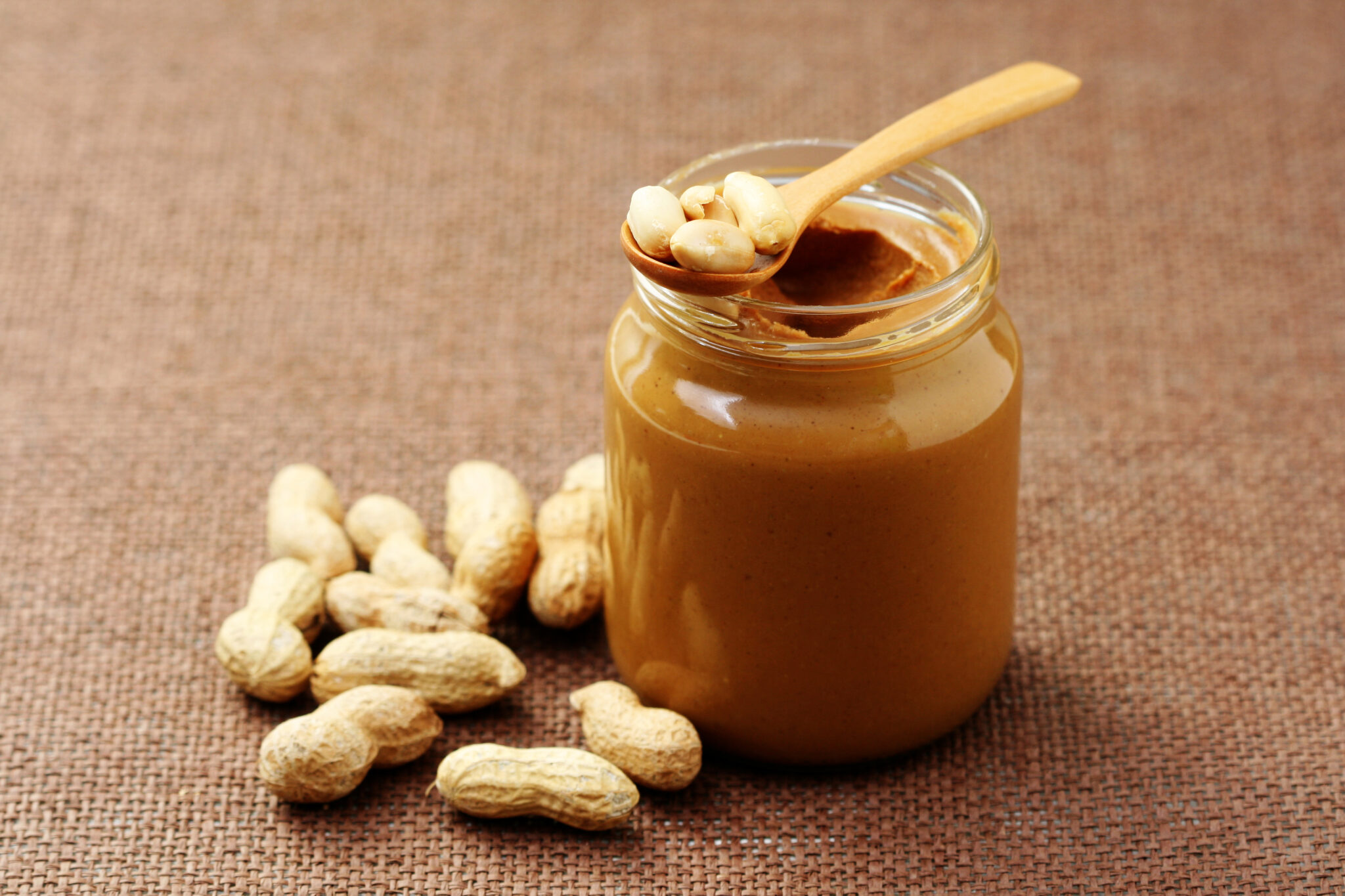 jar of peanut butter with spoon - food and drink