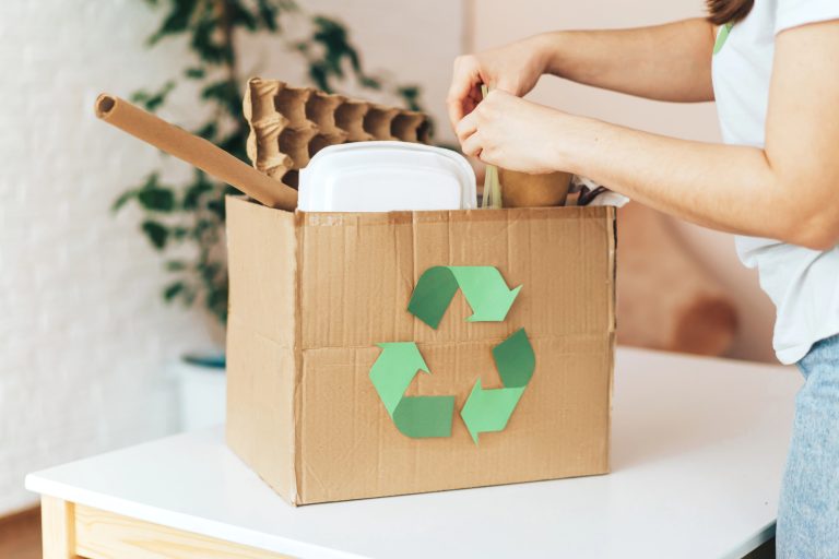 woman donating in box with used items, cardboard