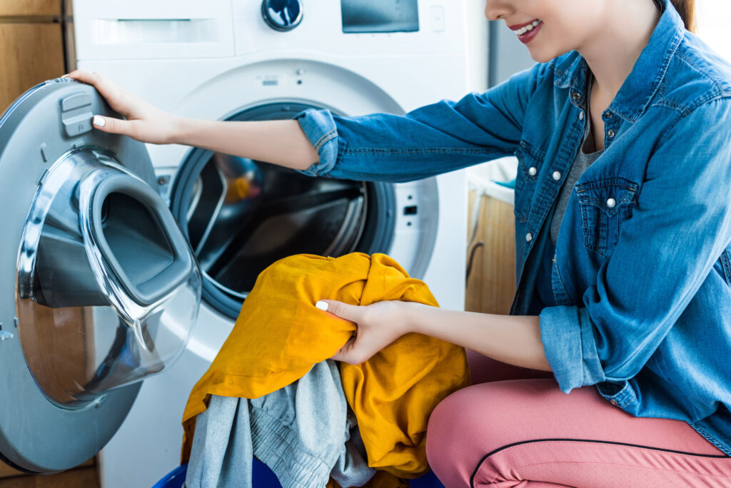woman putting clothes in washing machine