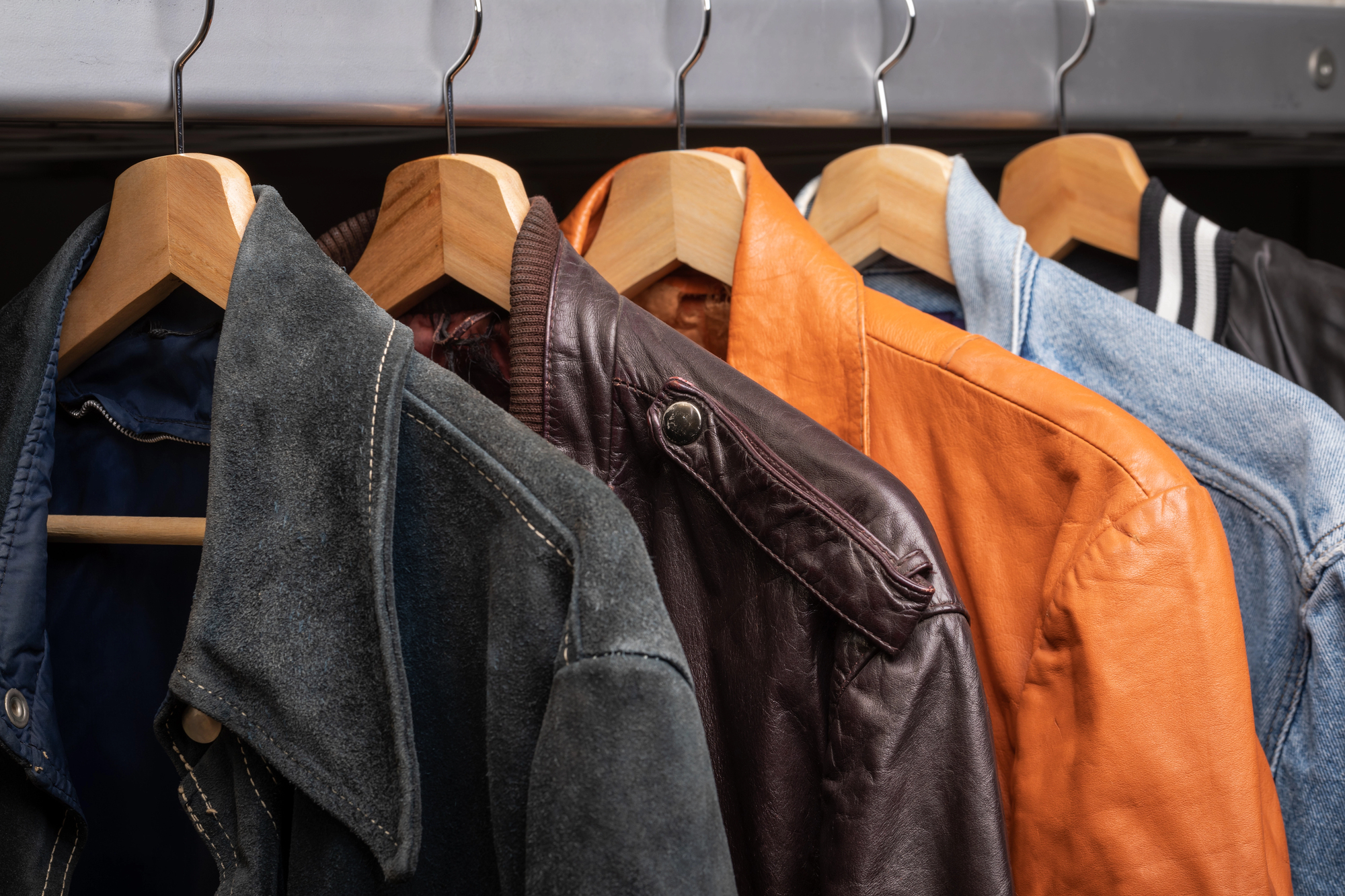 Various vintage suede leather and jeans jackets on hanger