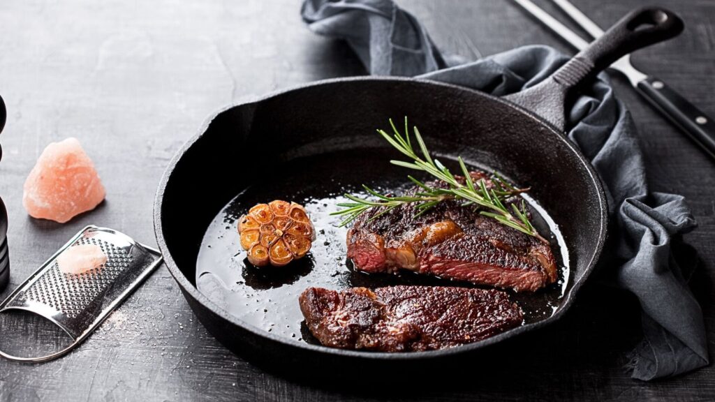 cast iron skillet with steak beef