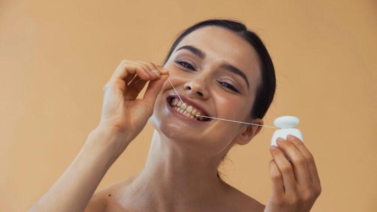 woman flossing teeth with dental floss