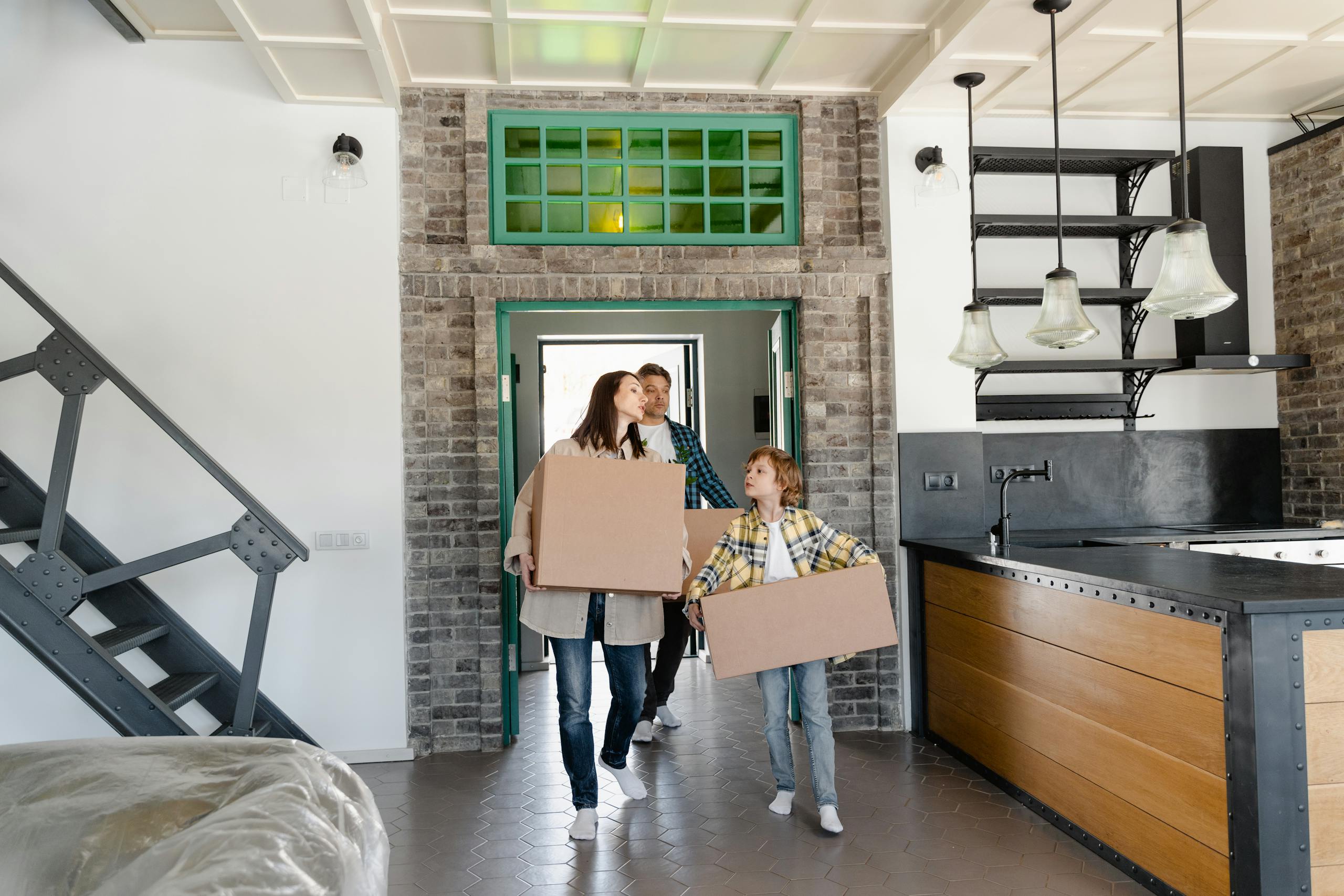 A Mother and Child Carrying Cardboard Boxes into the Kitchen Area
