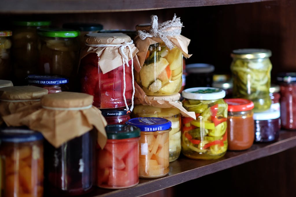 A shelf full of jars of pickles and other food