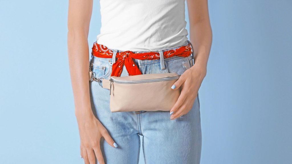 Young woman with beige leather clutch.