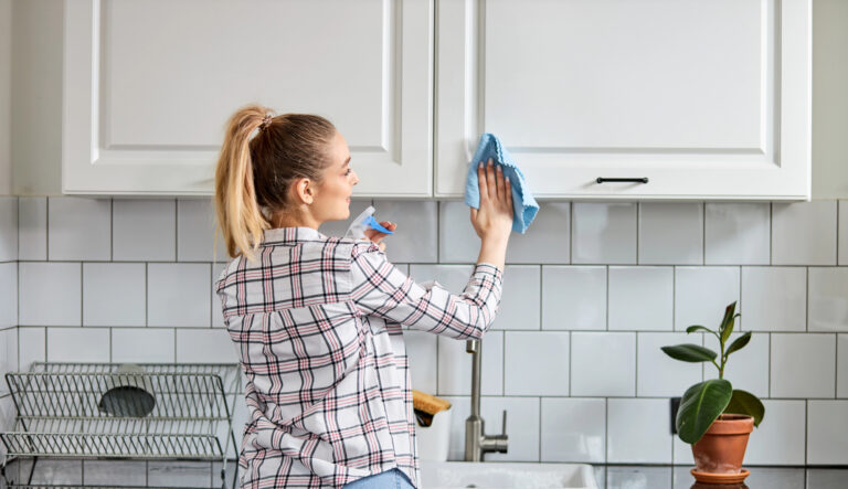 woman cleaning kitchen cabinet