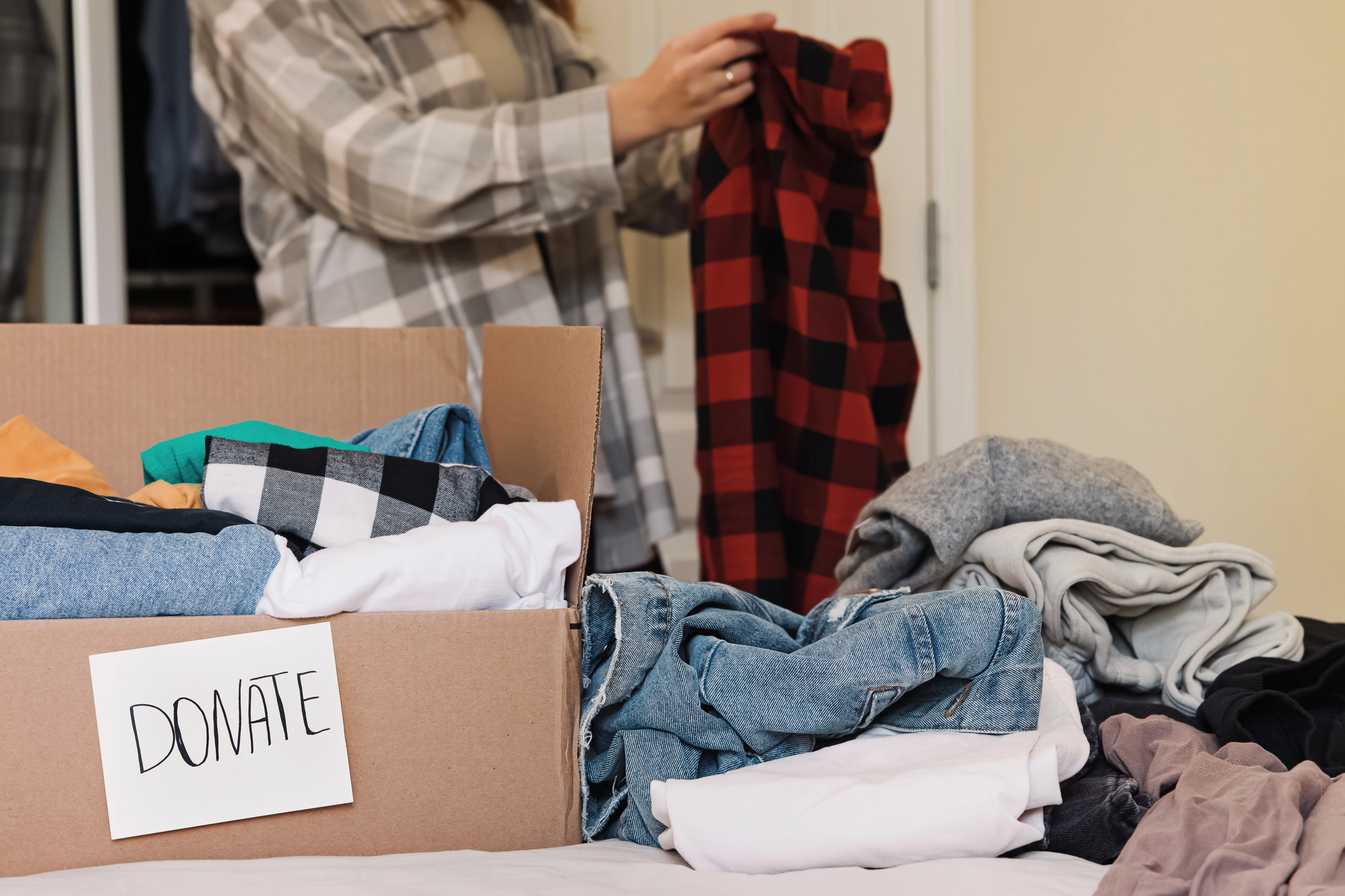person donating items folding clothes