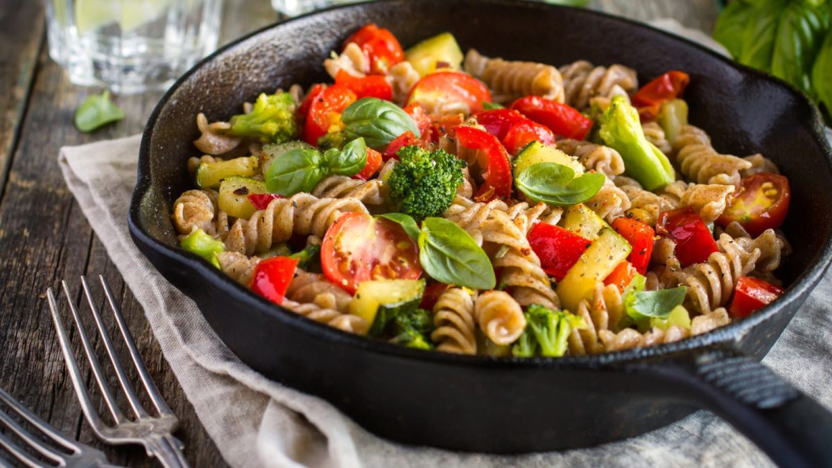 Whole wheat fusilli pasta with vegetables in a cast iron