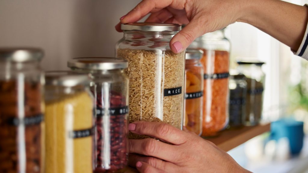 Woman Reusing Glass Jars To Store Dried Food