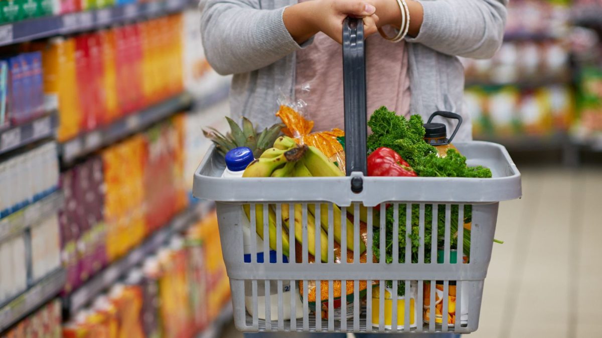 lady holding grocery basket with fruits and veggies