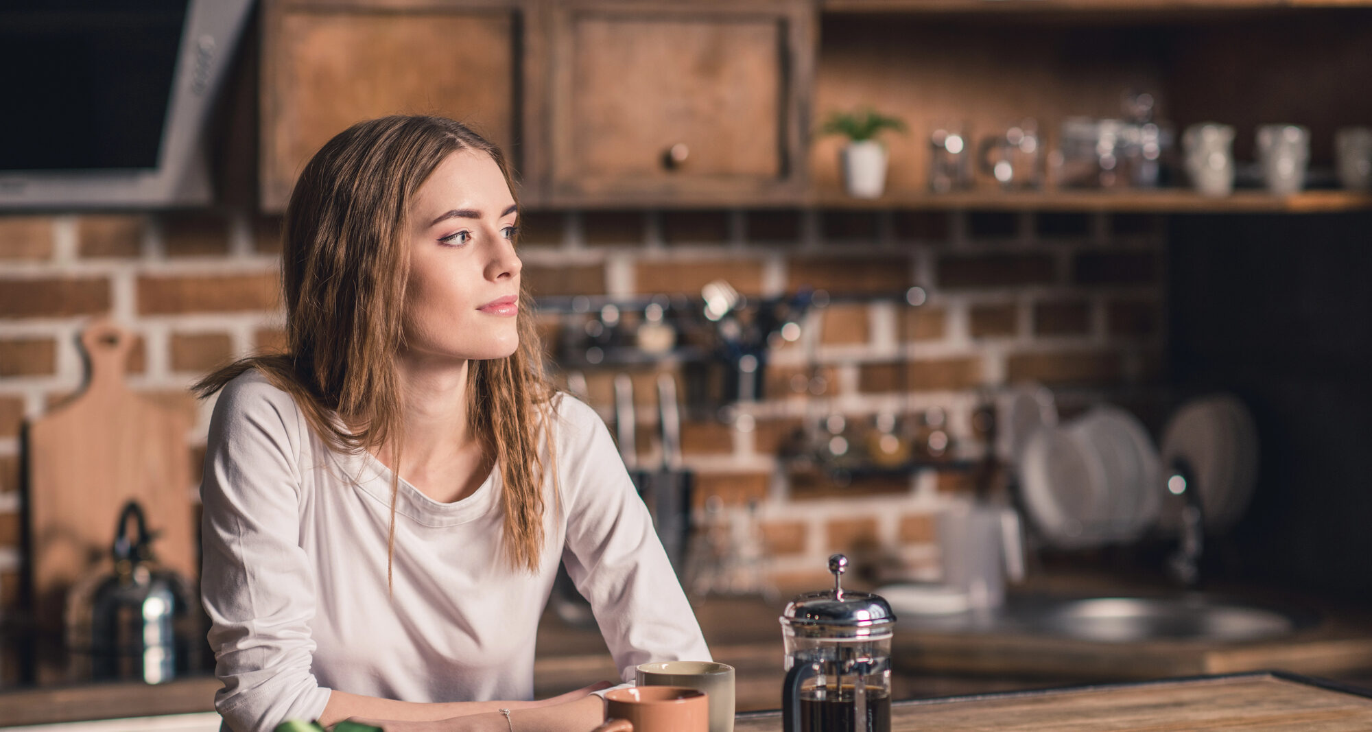 woman looking out drinking coffee