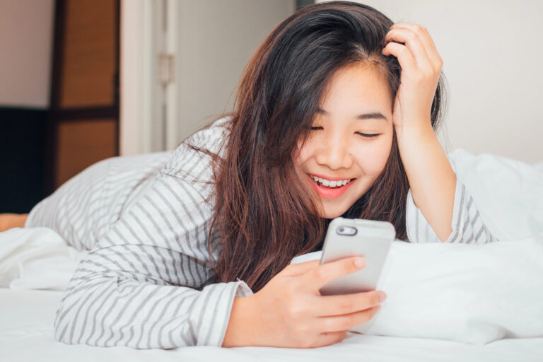 woman in bed looking at phone