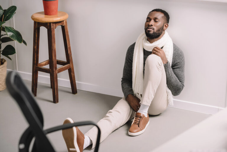 man sitting on floor worrying
