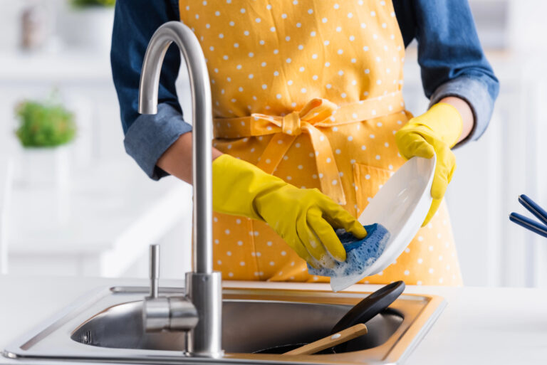woman is dish washing with sponge
