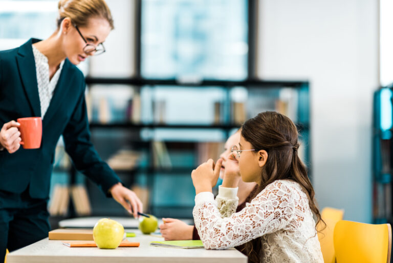 teacher holding mug in class with students