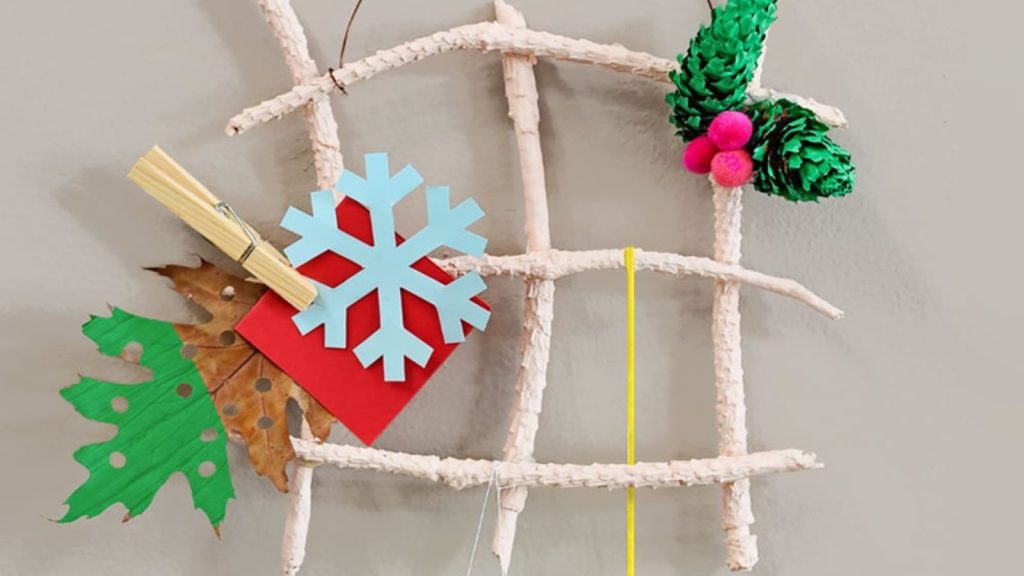 Use simple nature supplies to make your own DIY hanging holiday card holder. A festive activity for kids!
