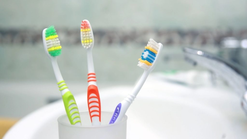 Three Toothbrushes in a bathroom. Close up shot of toothbrush.