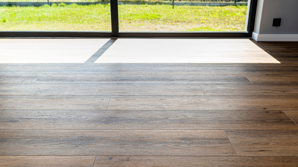 Modern vinyl panels imitating wood in the living room with selective focus and a shadow falling from the window (2)