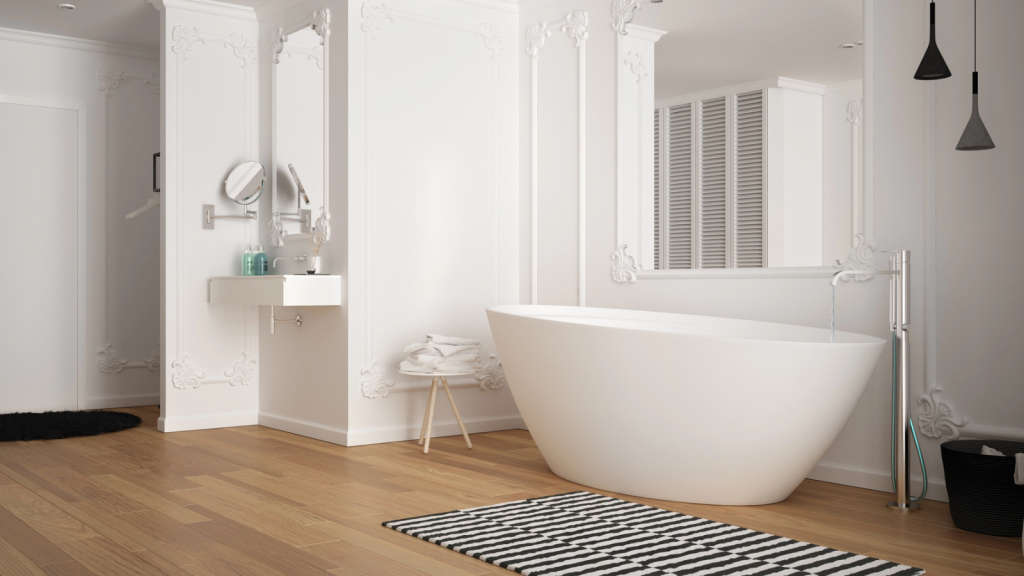 Modern white bathroom in classic room with wall moldings, parquet floor, bathtub with carpet and accessories, minimalist sink and decors, pendant lamps. Interior design concept