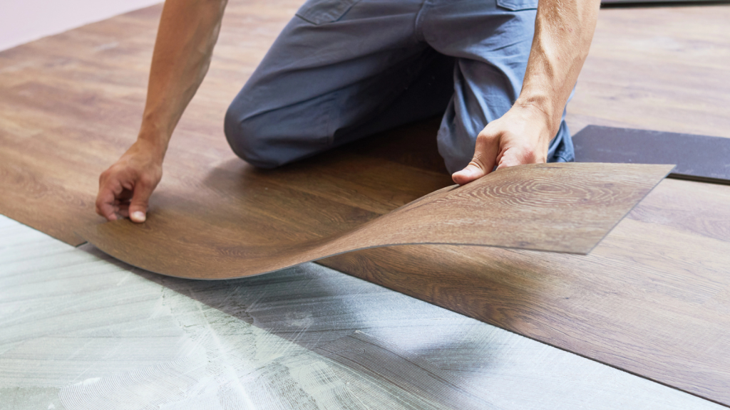 Worker joining vinyl floor covering at home renovation
