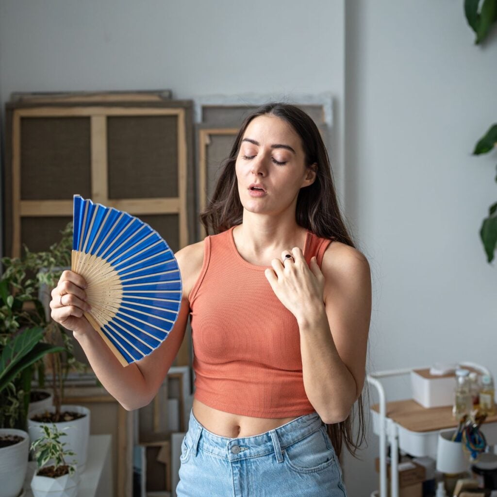 woman who is hot waving fan