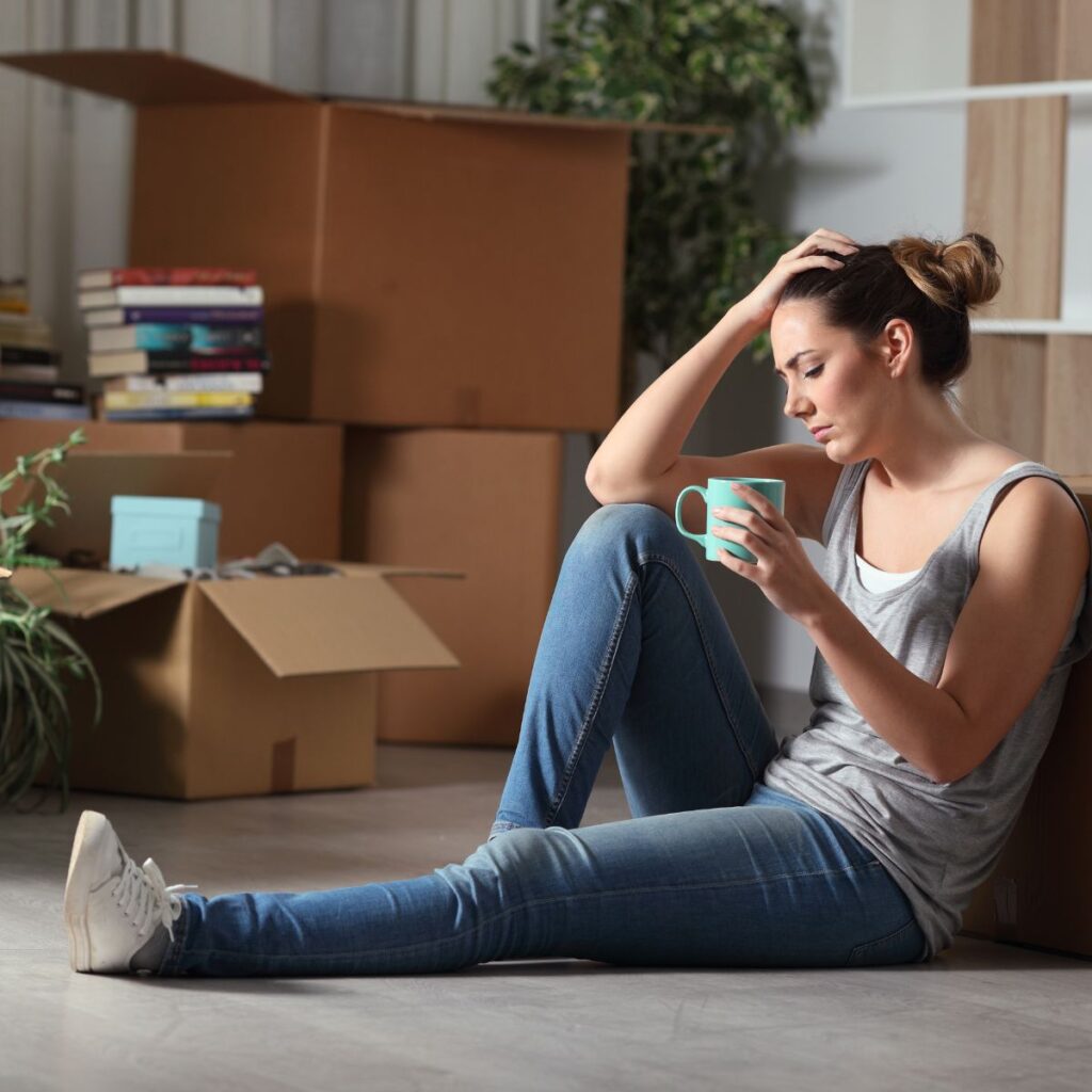young adult sad on floor in house