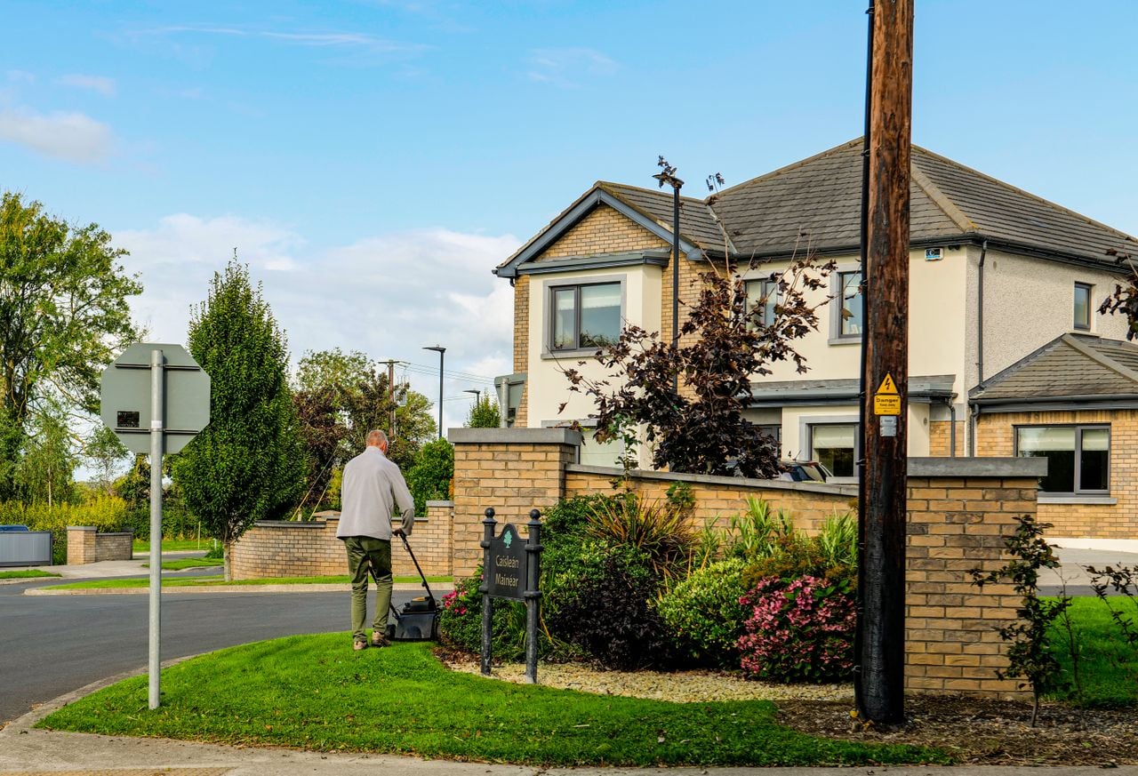 house with man mowing lawn