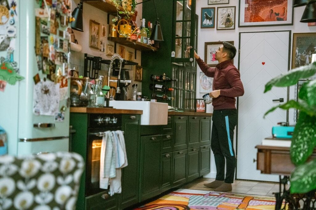 man looking in kitchen cabinets