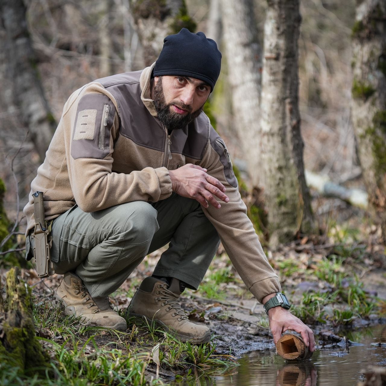 man in wilderness getting water