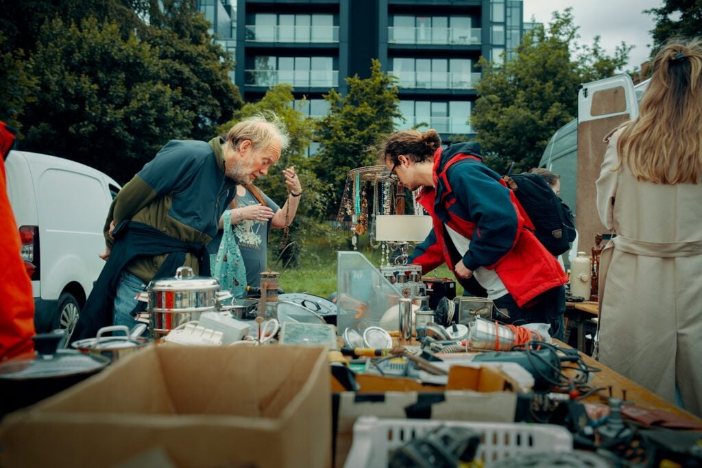 people searching table at a flea market