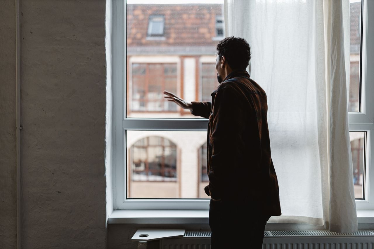 man looking outside a window