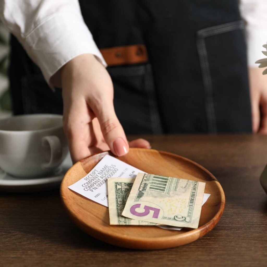 womans hand picking up tip
